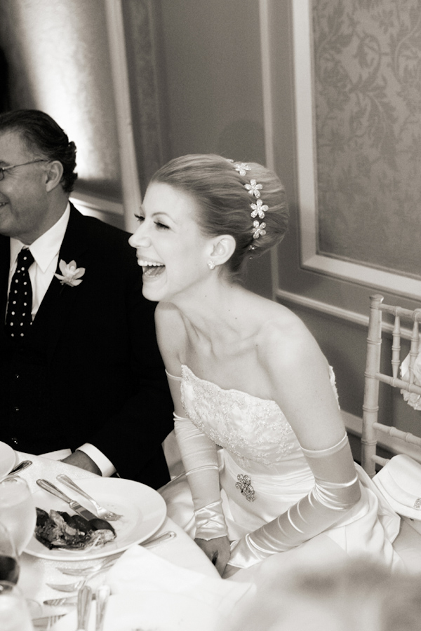 photo by New York based wedding photographer Merri Cry - black and white photo of the bride laughing while seated at her dinner table